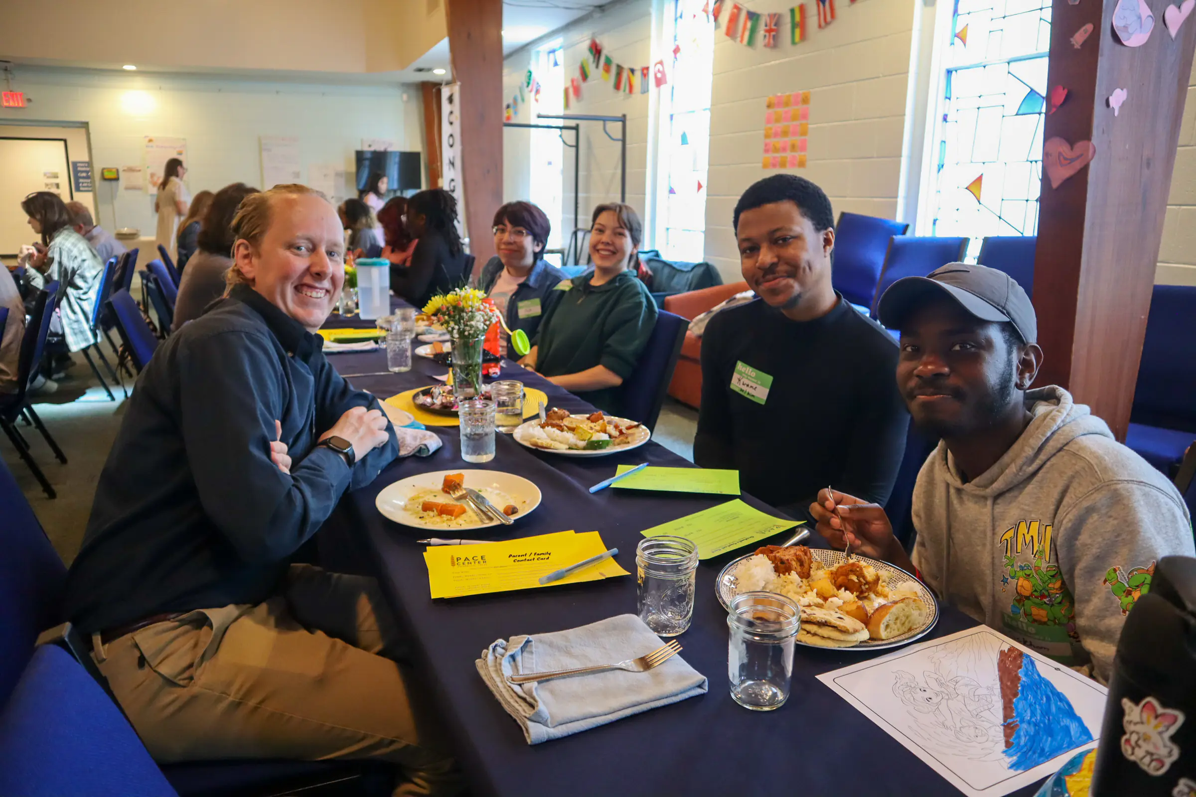 Campus Minister Russ Kerr eating lunch with two students at The Pace Center.
